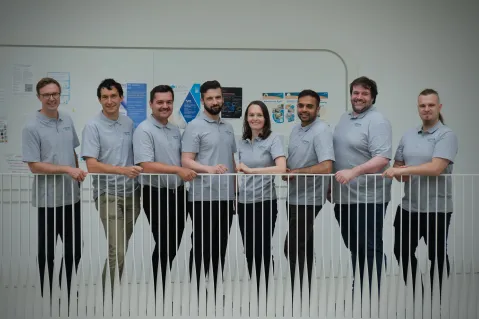 the collimatehealth team posing in front of banister wearing team shirts