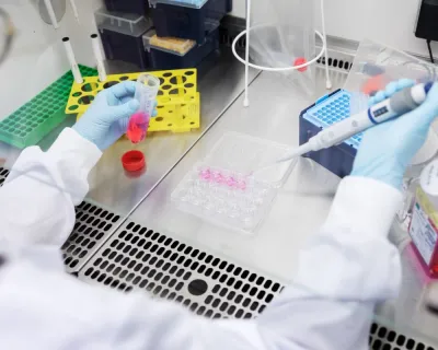 close up of scientist's arms with pipette