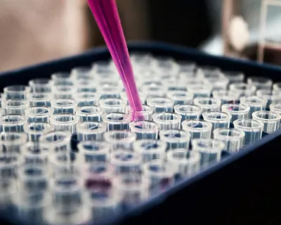close up of pipette over vials
